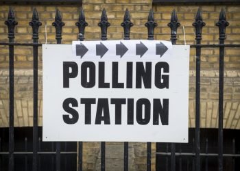Image of polling station sign to represent politics and article an assessment on Farage and Reform UK