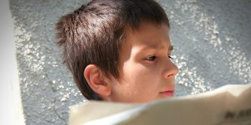 boy reading newspaper